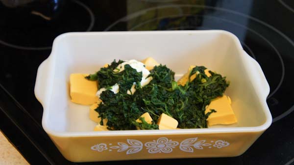 Velveeta cheese, cream cheese and spinach in a dish.