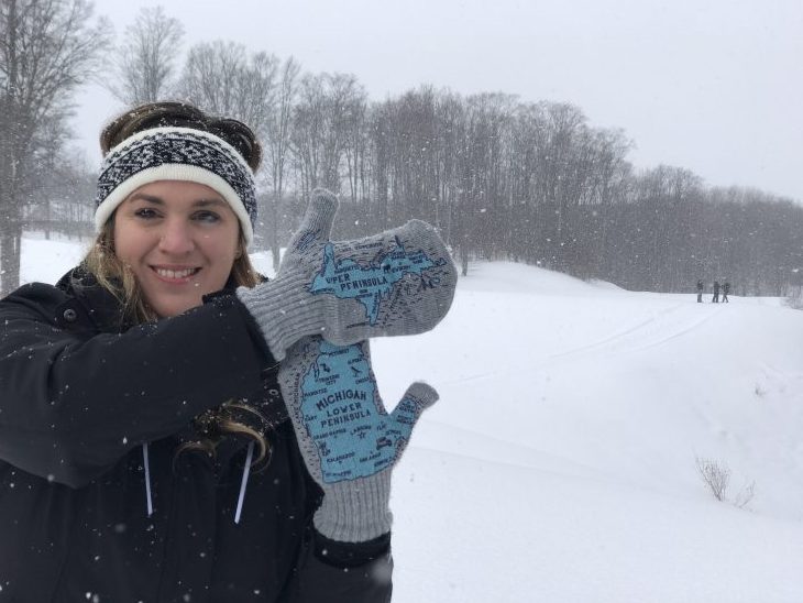 photo of a woman showing off her Michigan Mittens. 