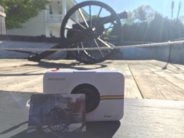 poloraid instant camera in front of cannon firing at fort mackinac