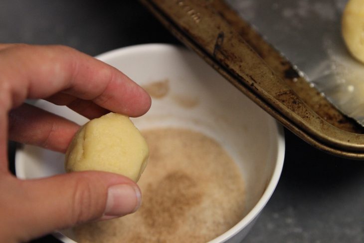 Photo of rolling the cookies in the cinnamon sugar mix.