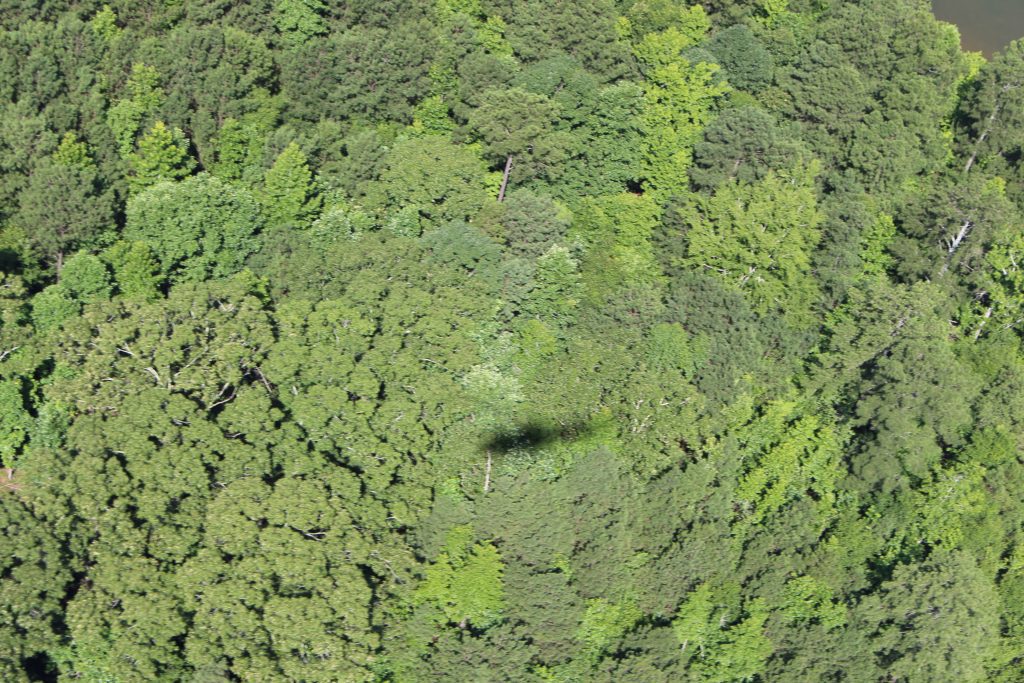 The shadow of the Huey Helicopter cuts across the land.