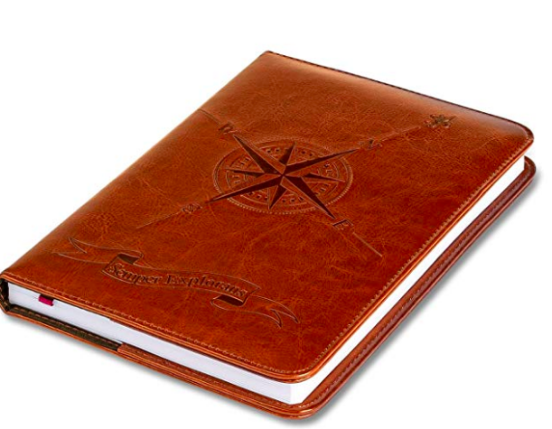 A photo of a leather travel journal with a compass on the cover.