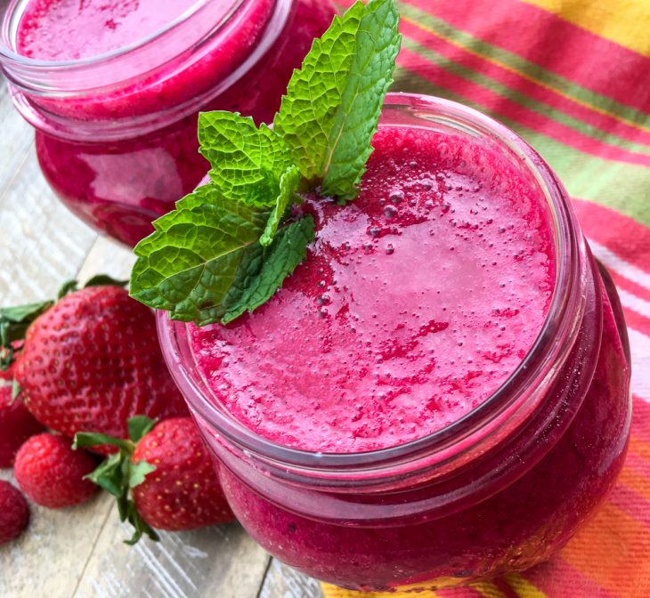 Berry Beet Smoothie in a mason jar garnished with a sprig of mint.