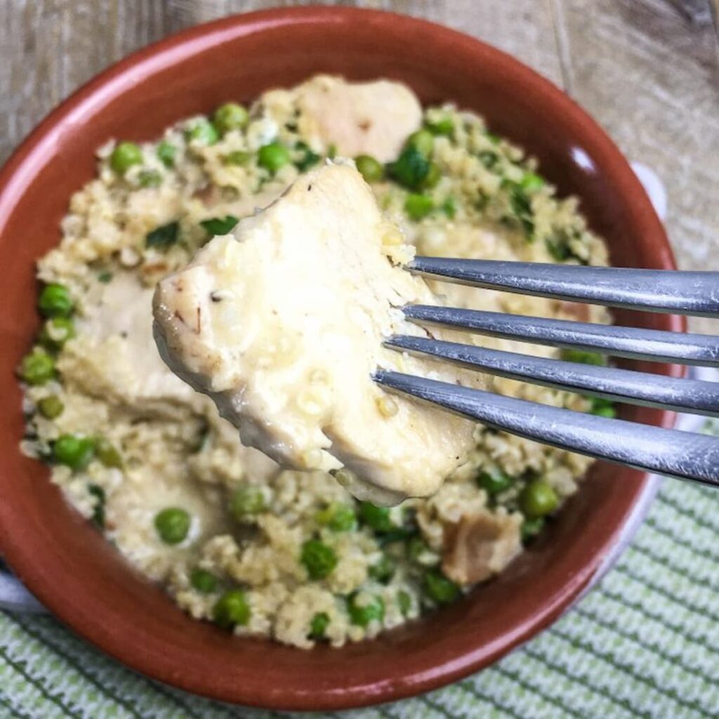 Chicken Quinoa and peas recipe with a piece of chicken on a fork.