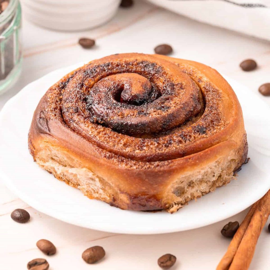 large Coffee Cinnamon Roll on a white plate.