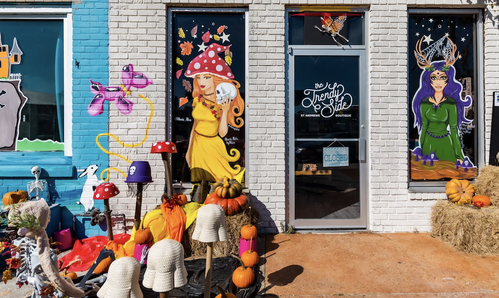 Historic St Andrews store front windows decorated for fall with folklore characters.