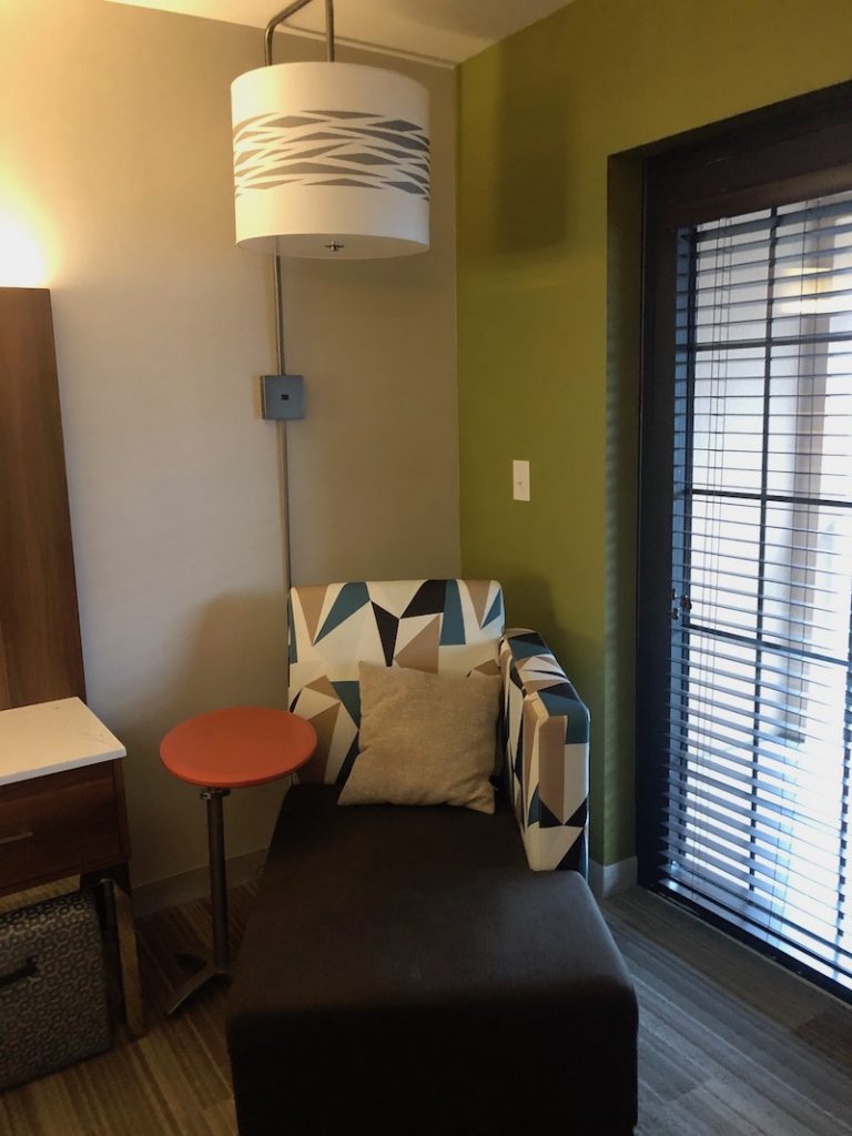 photo of a reading chair and lamp by a window at the Holiday Inn Express.