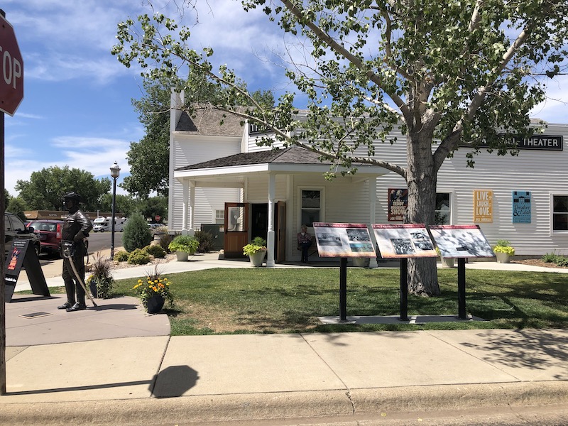 white building with sotry signs in front of it in downtown Medora