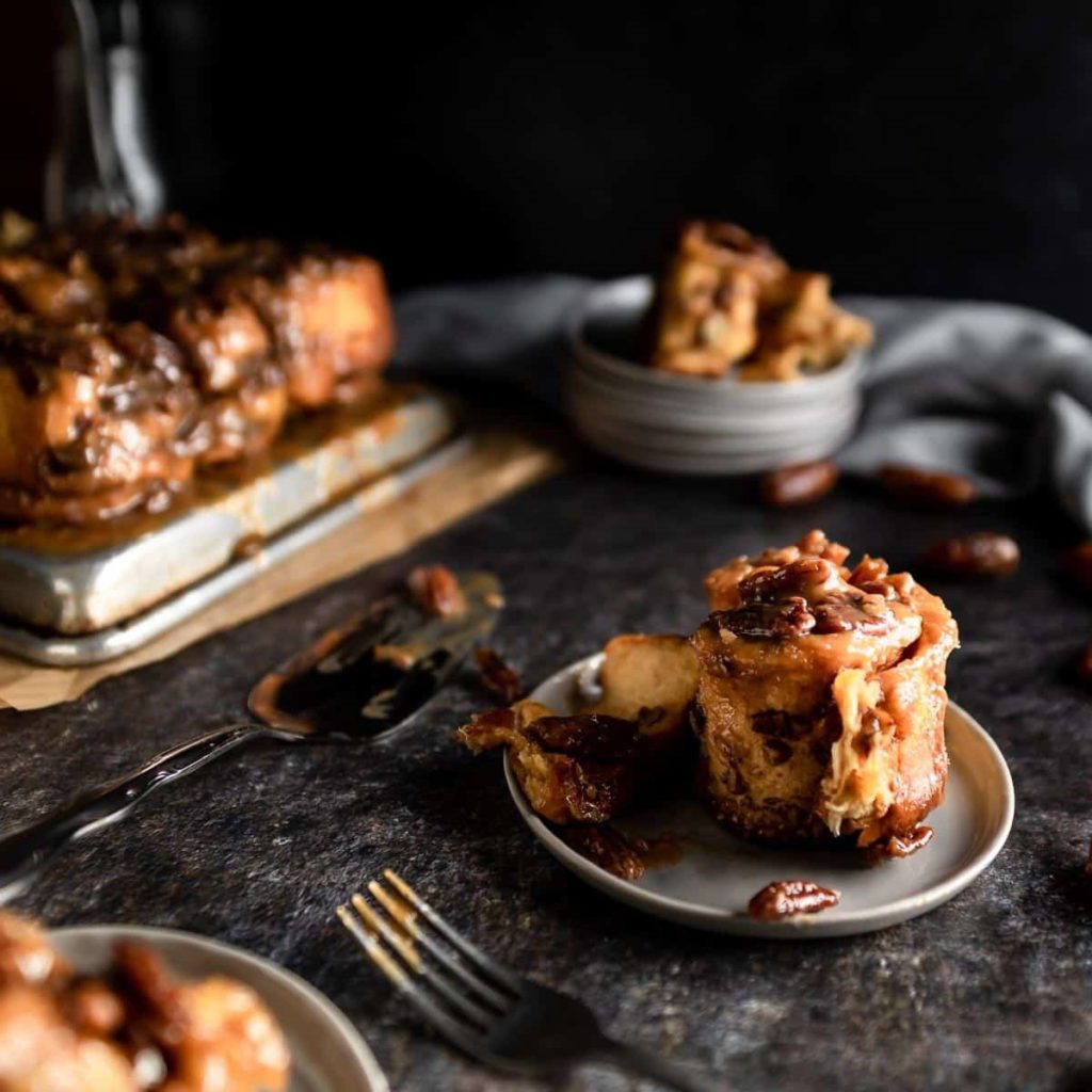 Ooey Gooey Sticky Toffee Pecan Buns on a dark table