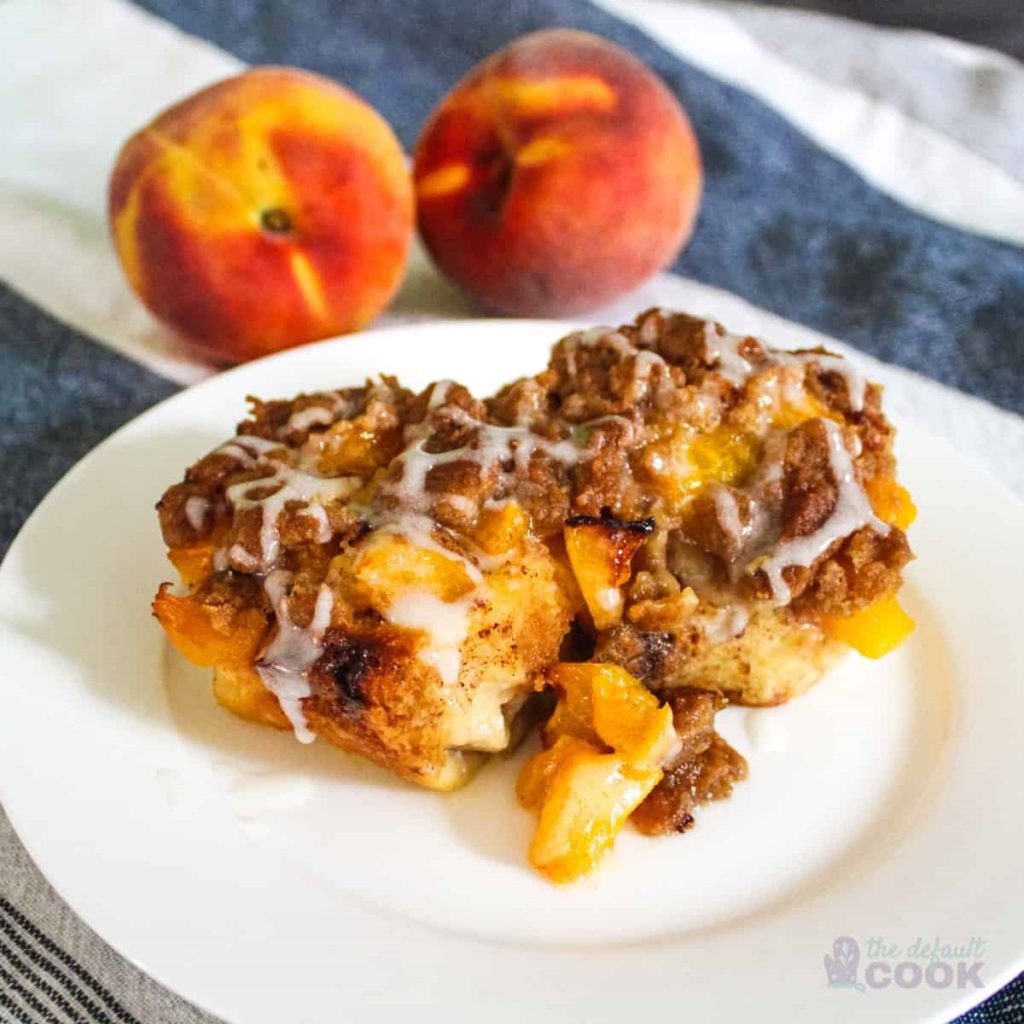 Peach Cobbler Cinnamon Rolls on a white plate.