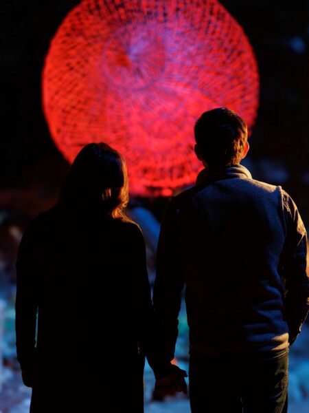 Rock City Flora Fluna red ball lantern with couple standing in front of it at night.