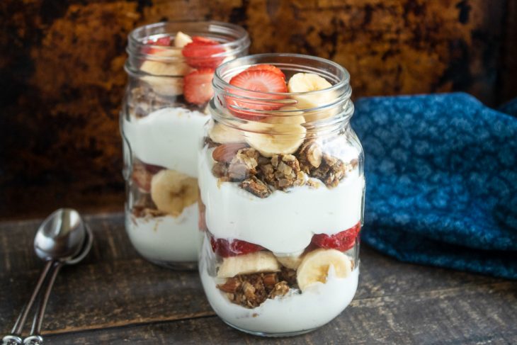 Granola Parfaits with yogurt and strawberries in a mason jar.