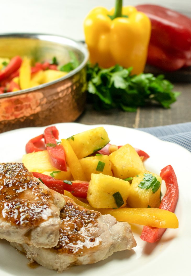 Sweet and sour pork chops with a side of peppers and pineapple.
