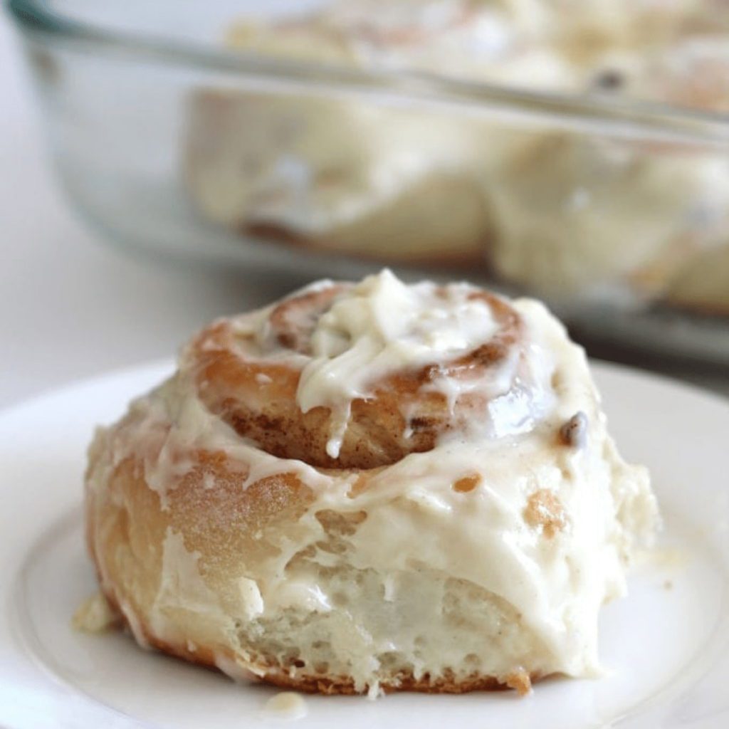 a Soft Cinnamon Roll on a white plate. The perfect christmas brunch recipes to make ahead of the big day.