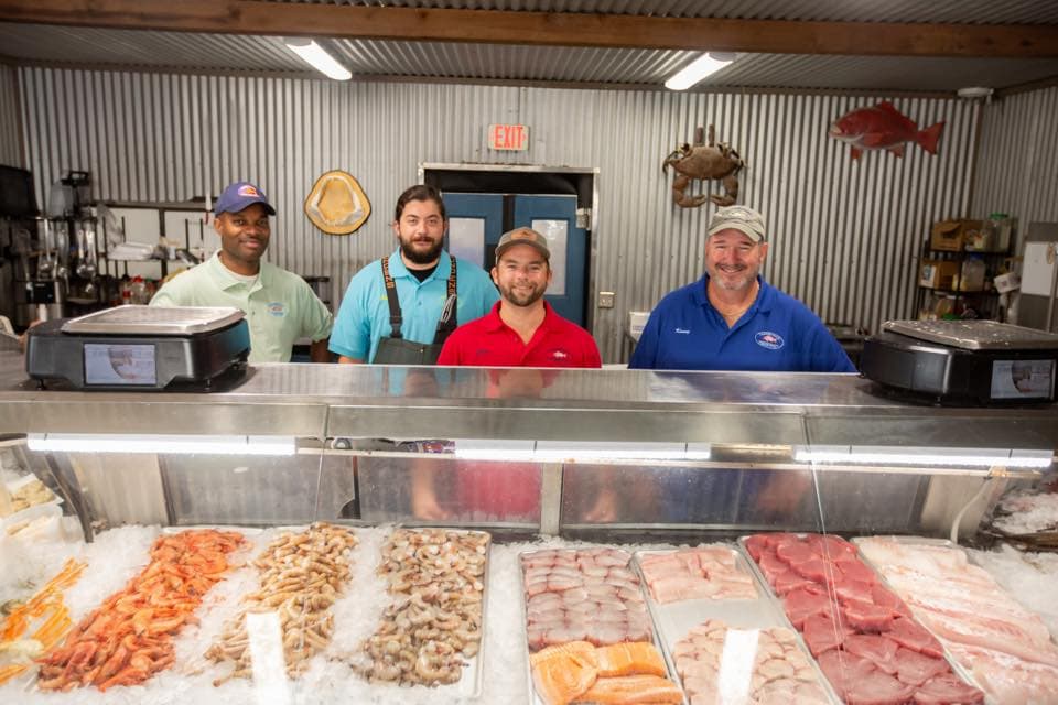 Tarpon Dock employees behind fresh seafood case.