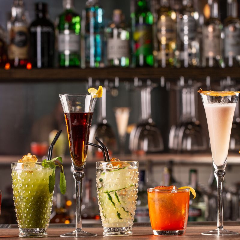 Photo of multiple cocktails on a  bar.