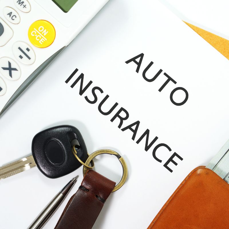 auto insurance document with car keys laying on top