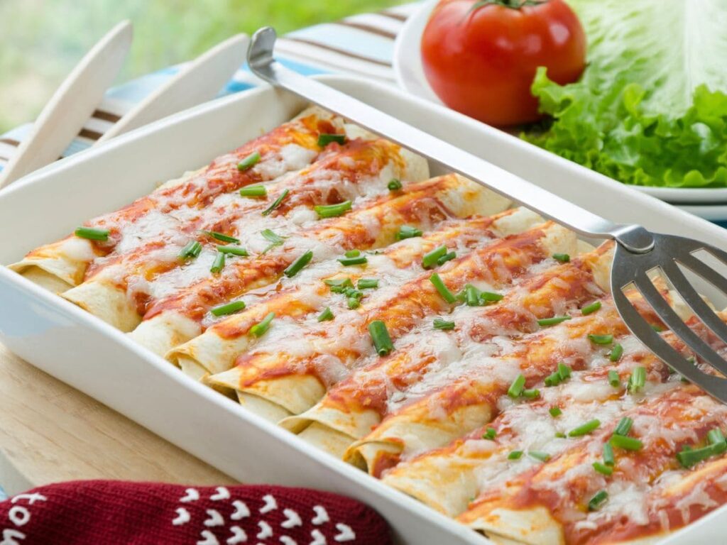 chicken and black bean enchiladas in a white baking dish.