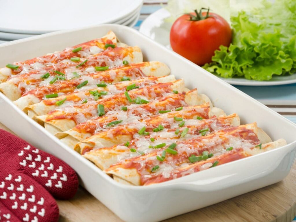 chicken and black bean enchiladas in a white baking dish.