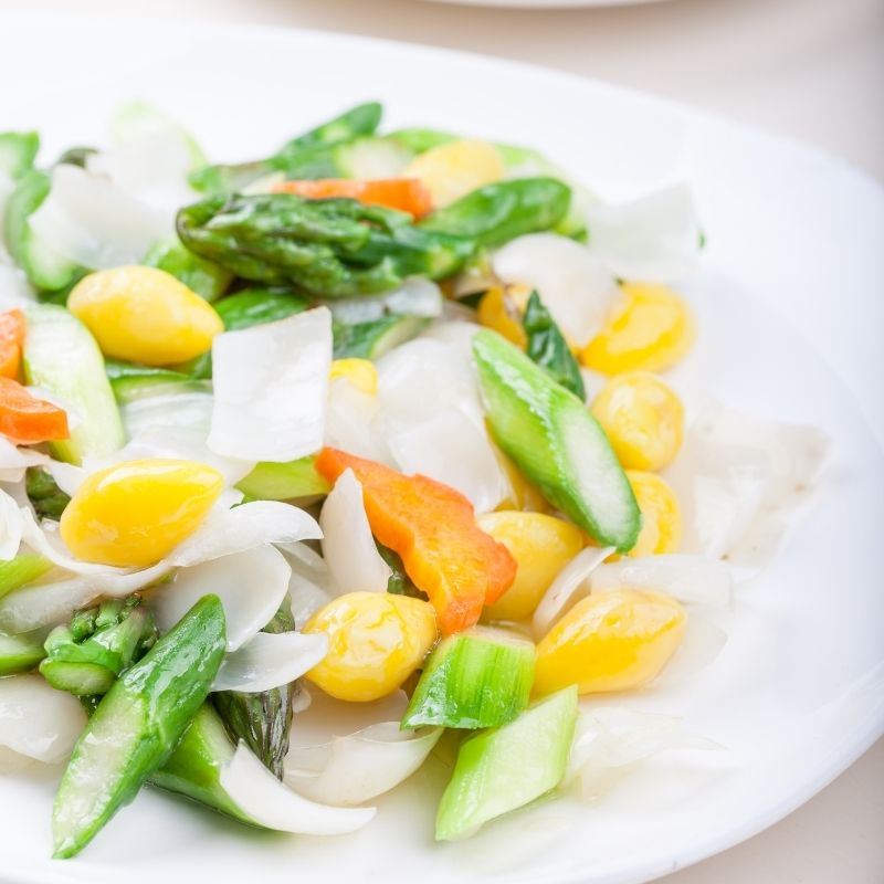 white plate with green, yellow and orange vegetables