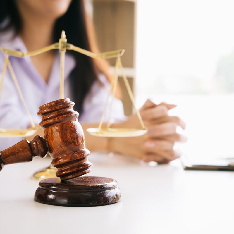 lawyer with hands folded resting on table with a gavel