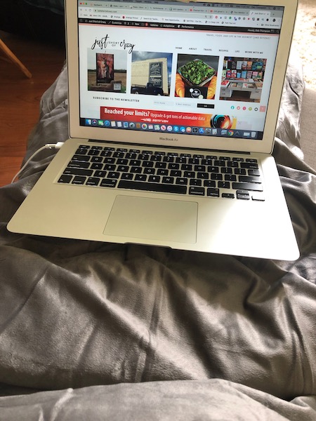 grey weighted blanket by trankquility across lap with laptop computer on top showing the web page just short of crazy 